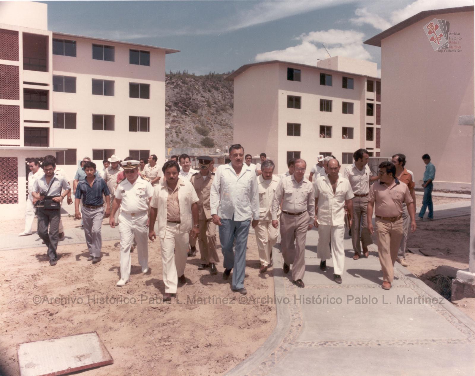 Alberto Andrés Alvarado Arámburo y acompañantes caminando entre edificios.