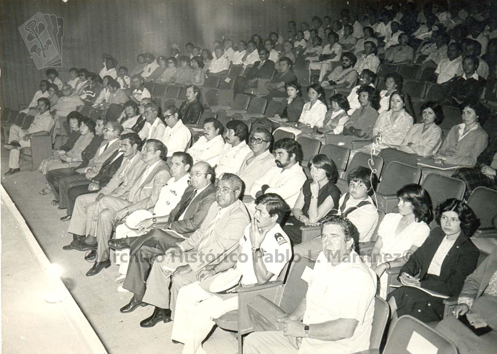 Alberto Andrés Alvarado Arámburo y acompañantes sentados en primera fila en un auditorio.
