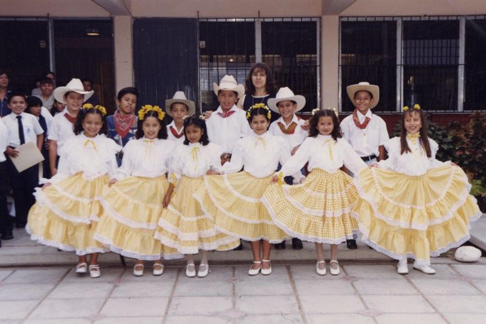 “Alumnos de la escuela Revolución de 1910, portan vestuario representativo del baile de “Las Calabazas”, acompañados por la profesora Sandra Hampl Quiroz”