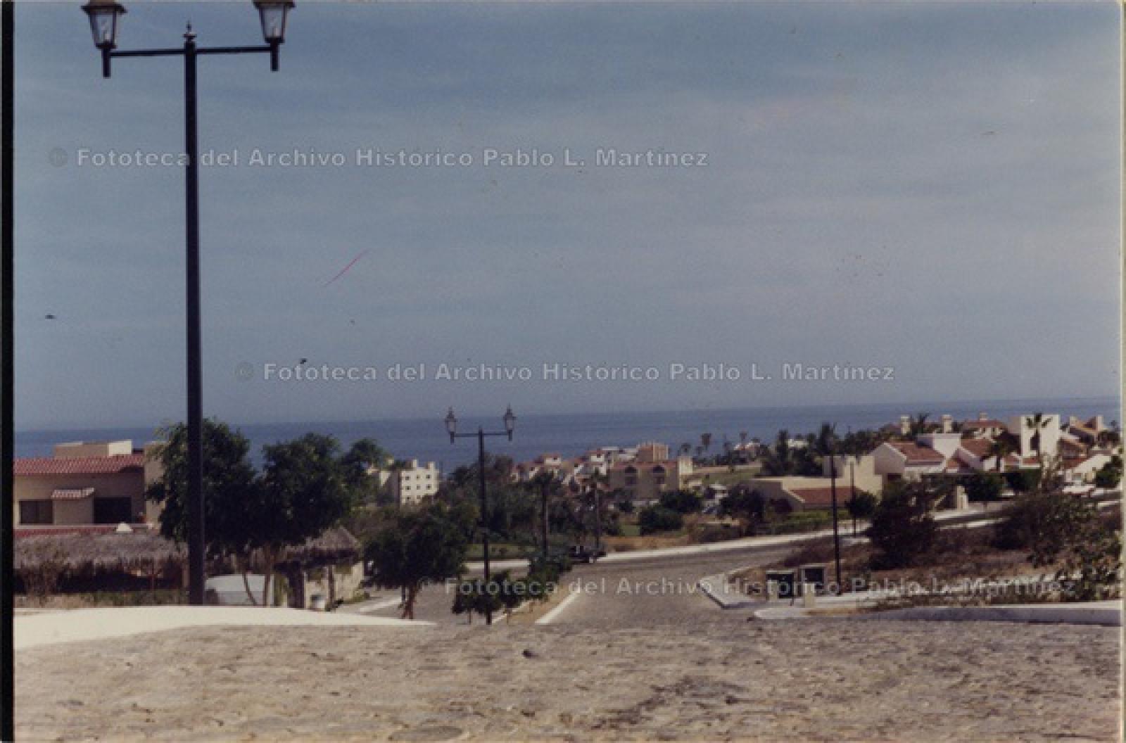 Calle empedrada, con el mar de fondo.