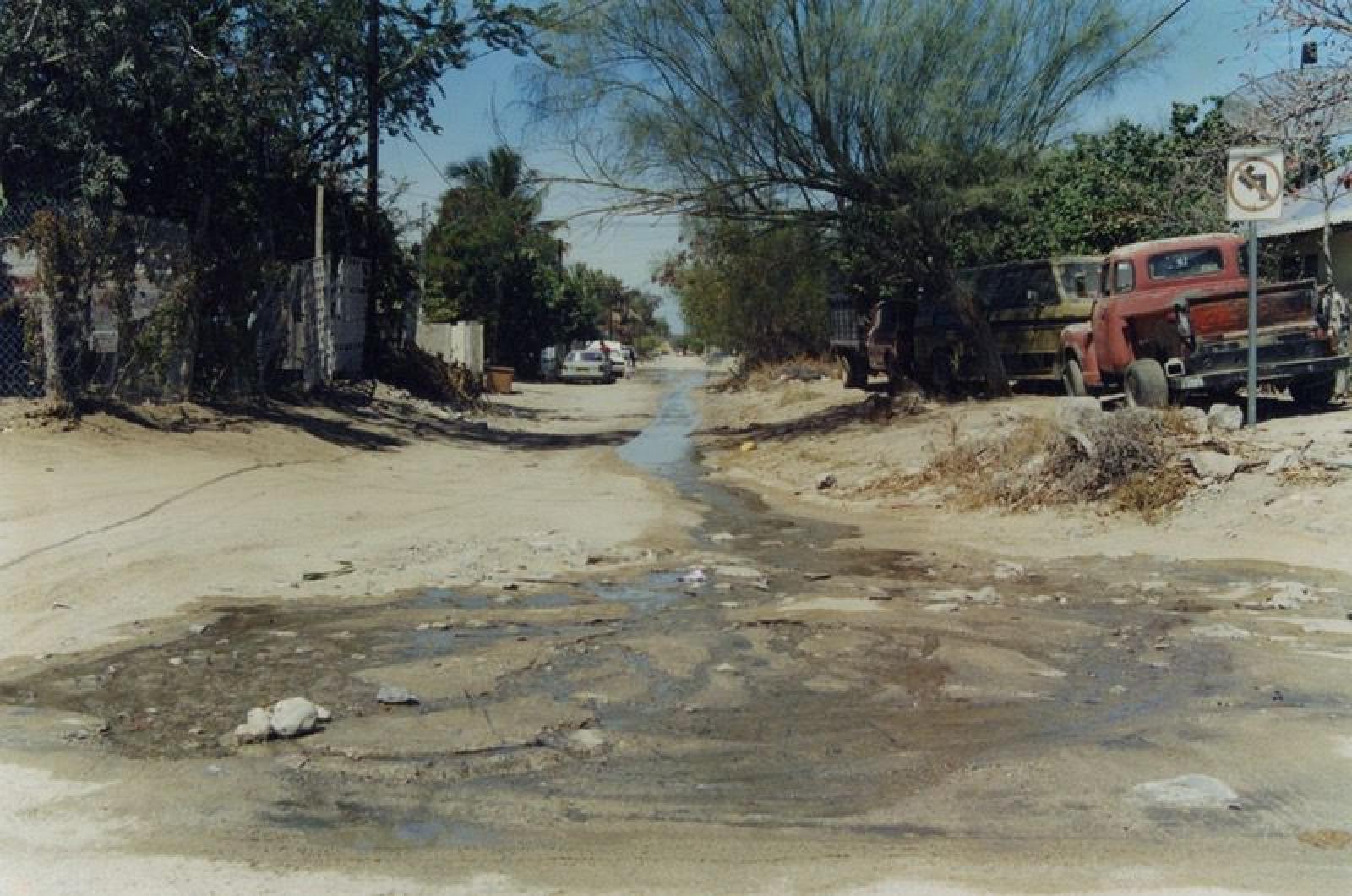 Calle sin pavimentar y con encharcamientos.