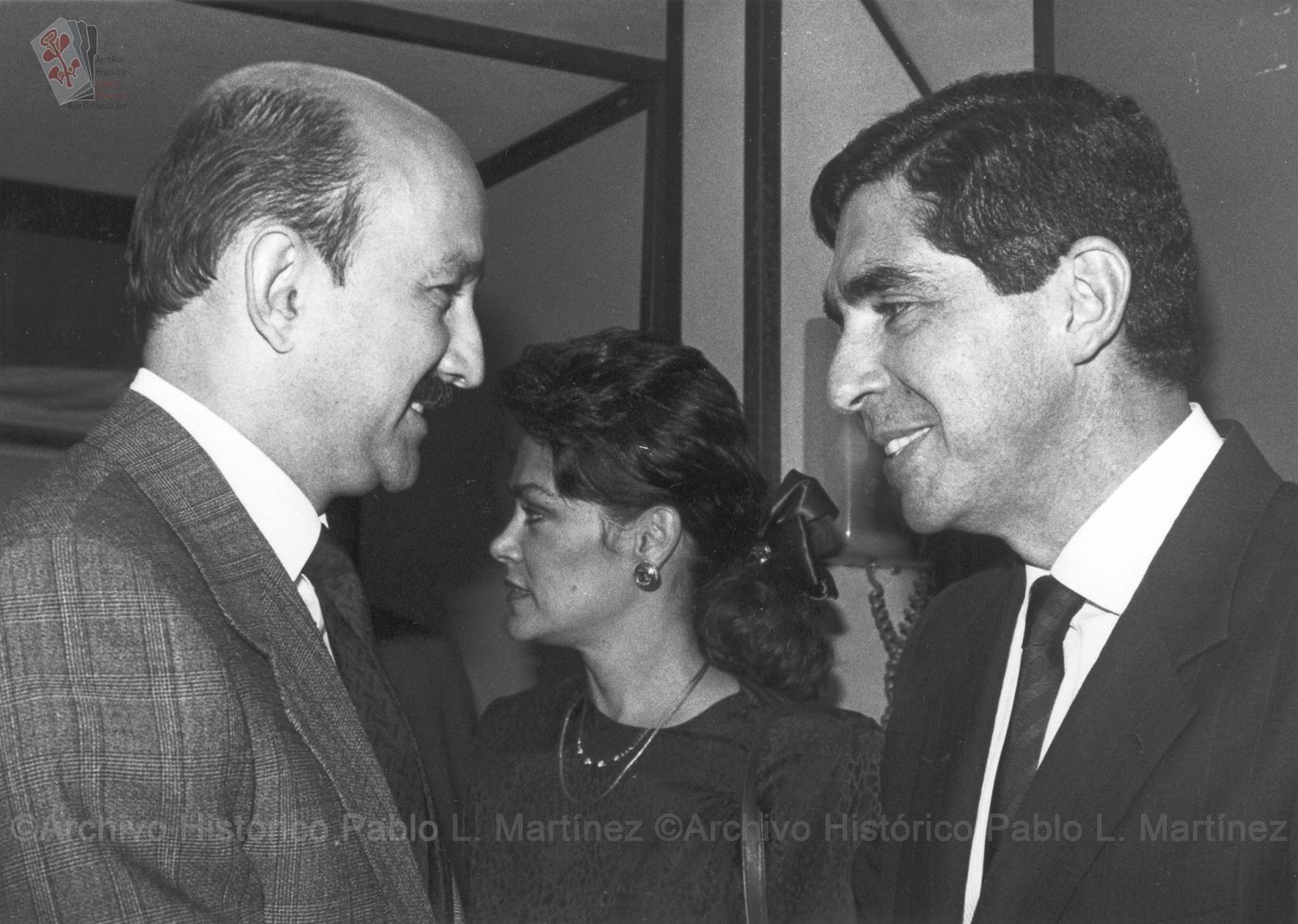 Carlos Salinas de Gortari saluda a dos personas.