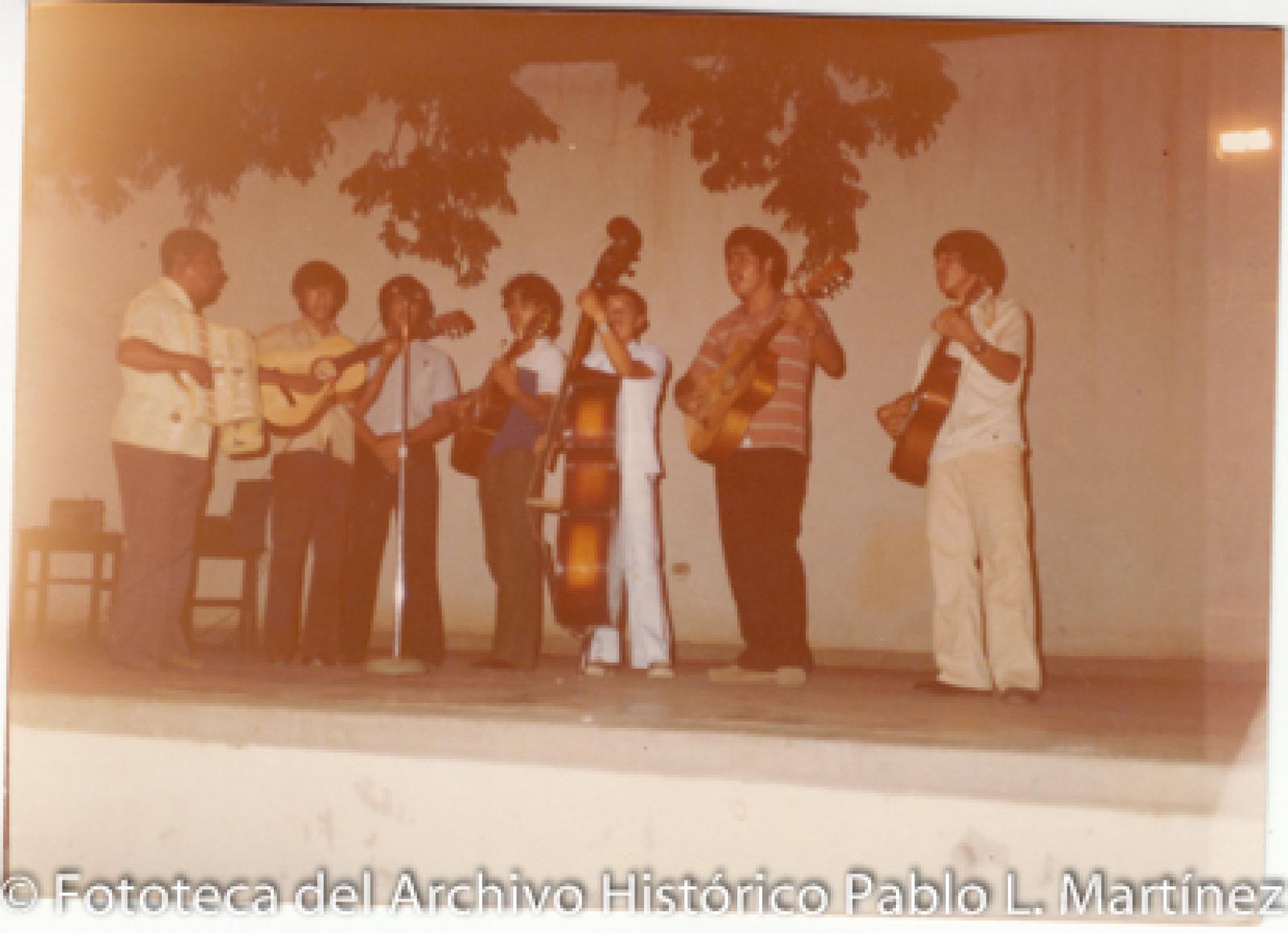 Hombres en escenario con instrumentos musicales