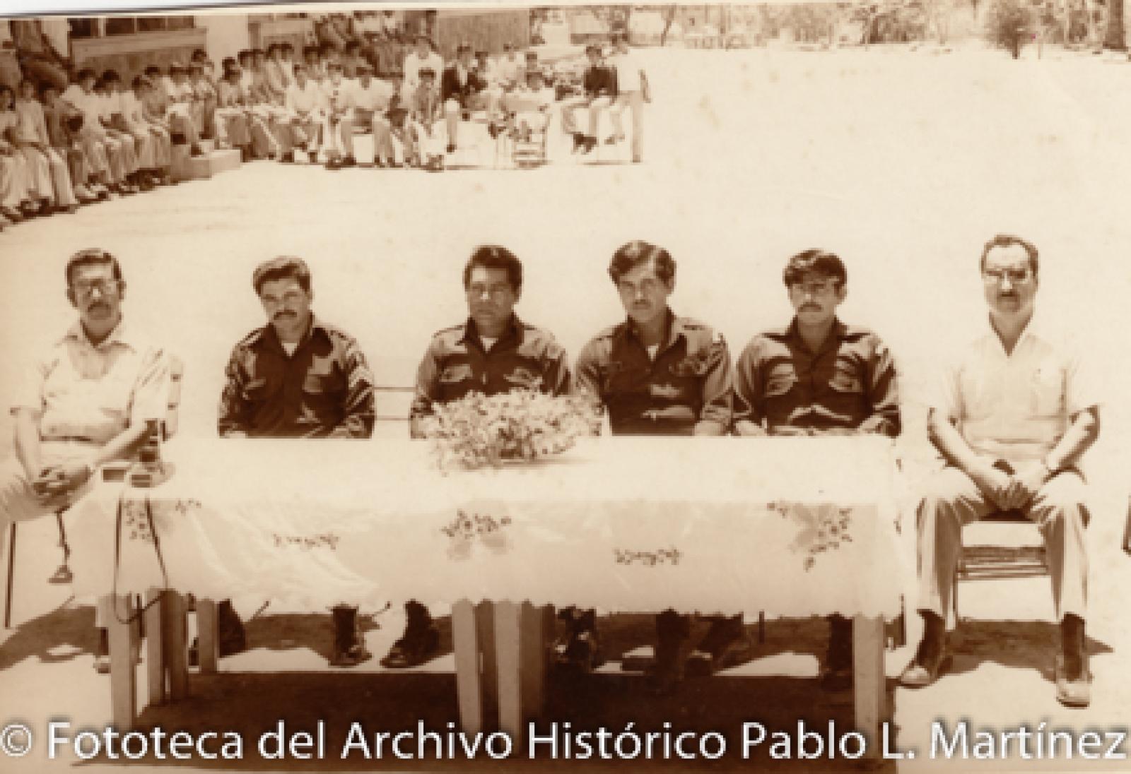 Hombres, niñas y niños en evento cívico escolar.