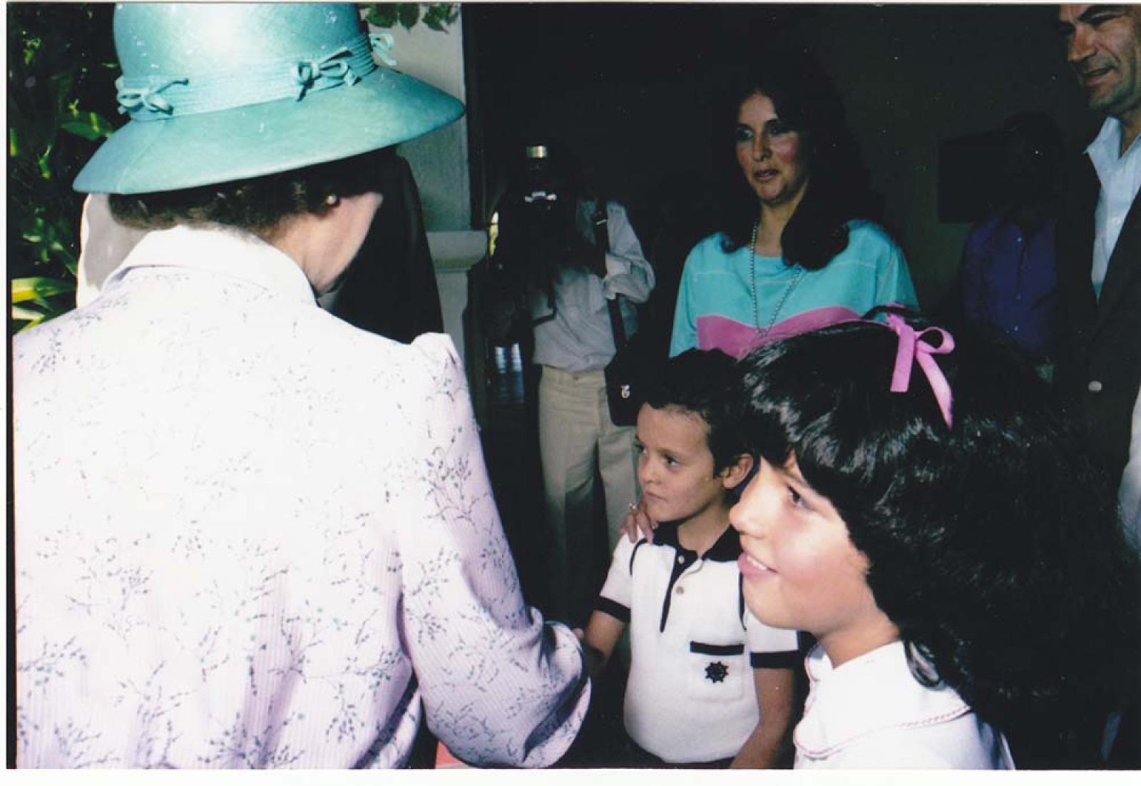 La reina Isabel II saluda a niño.