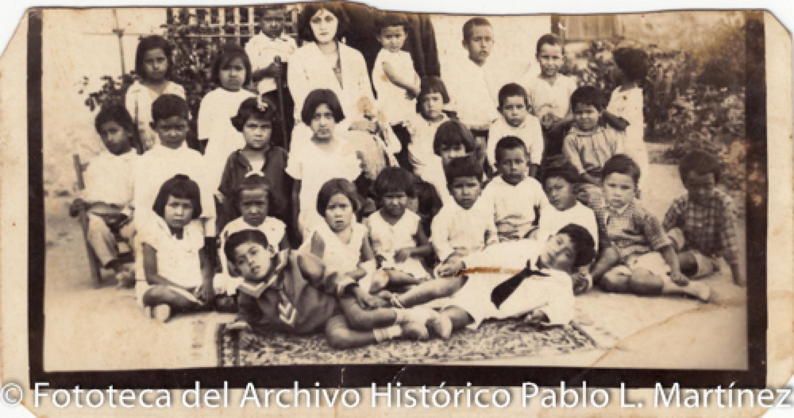 Mujer, niños y niñas en patio.