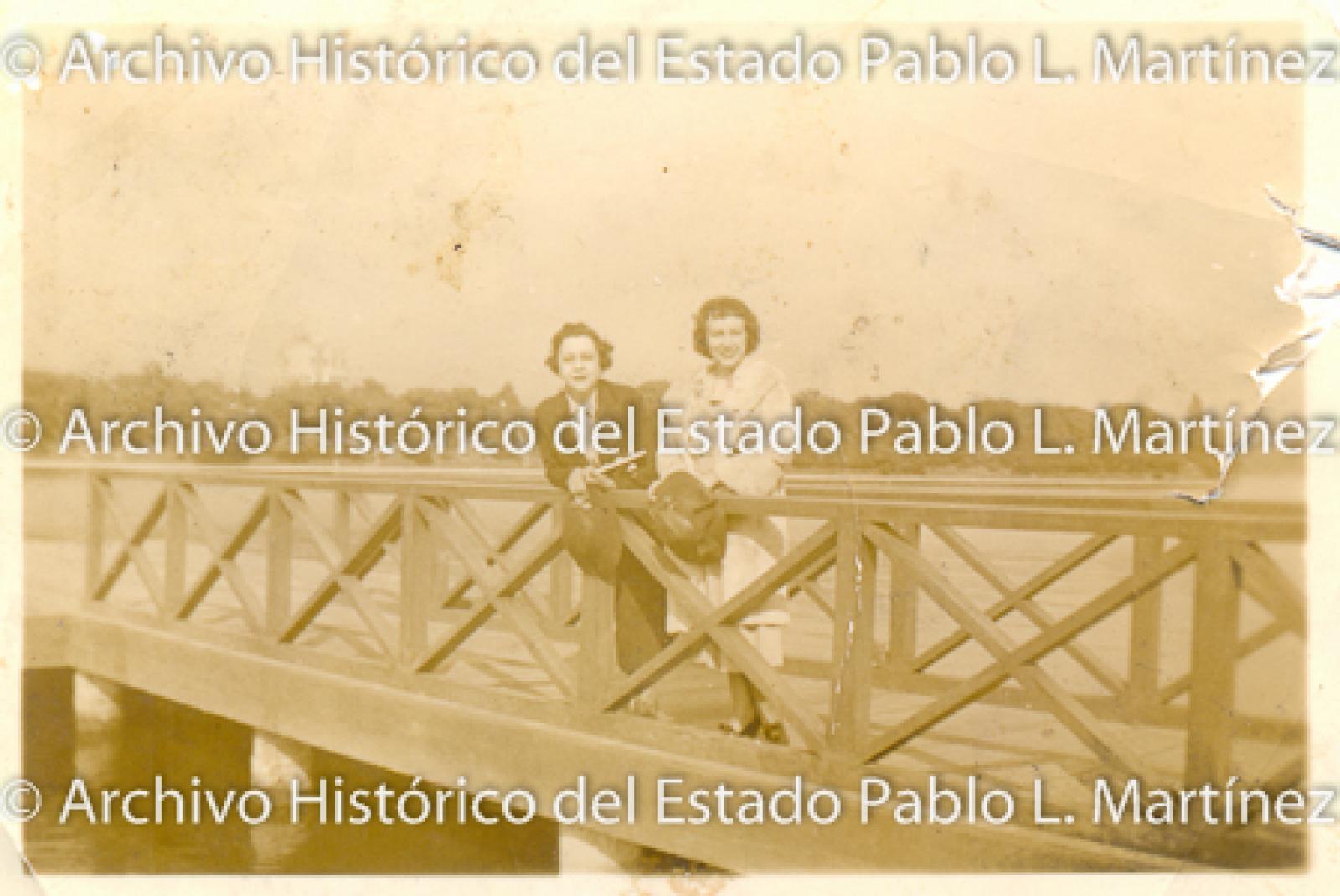 Mujeres sobre muelle.