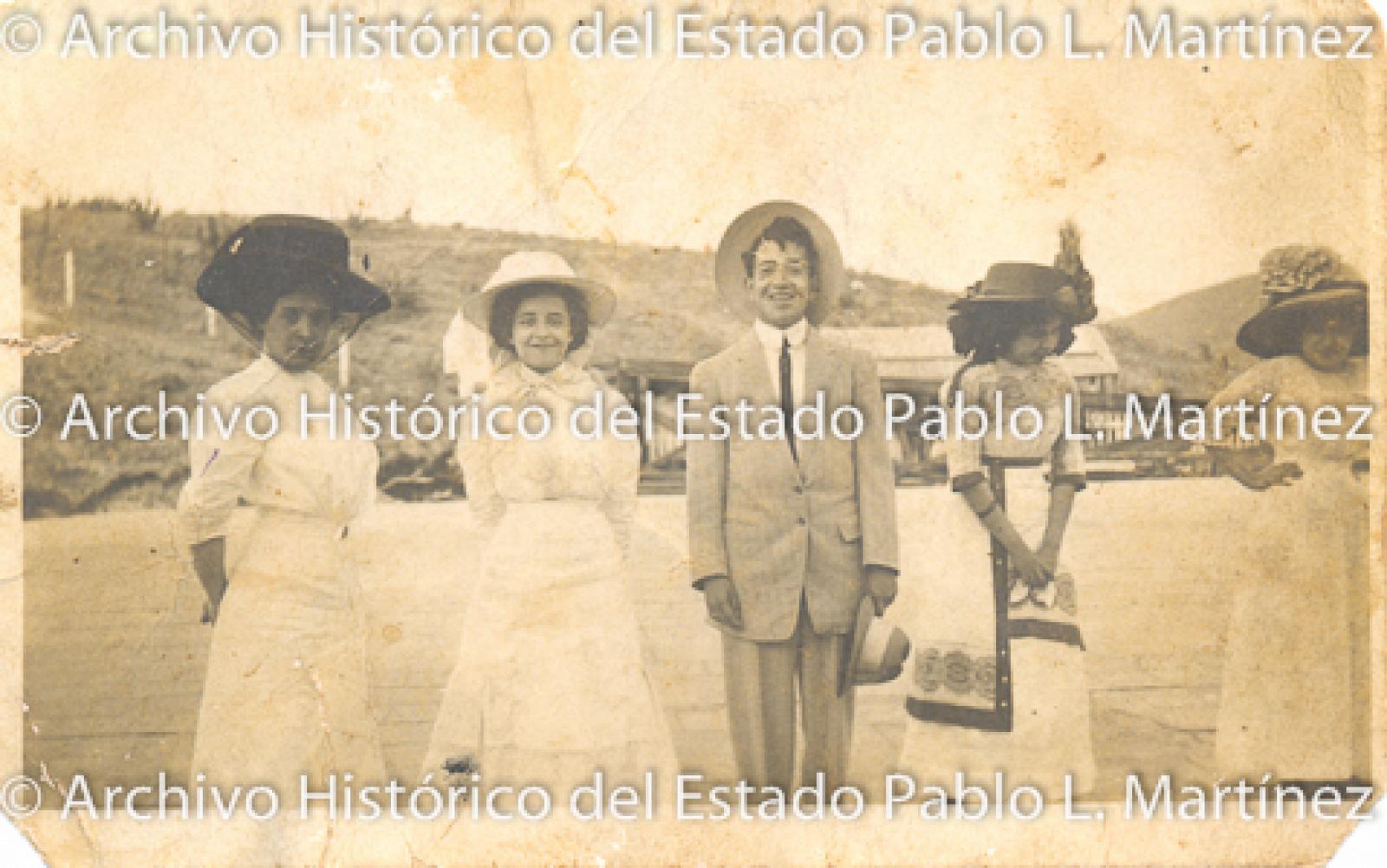 Mujeres y hombre frente a paisaje rural, retrato.