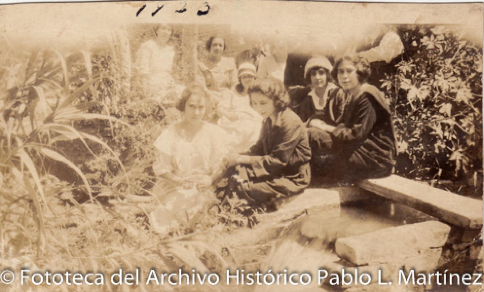 Mujeres y hombres frente a acueducto.