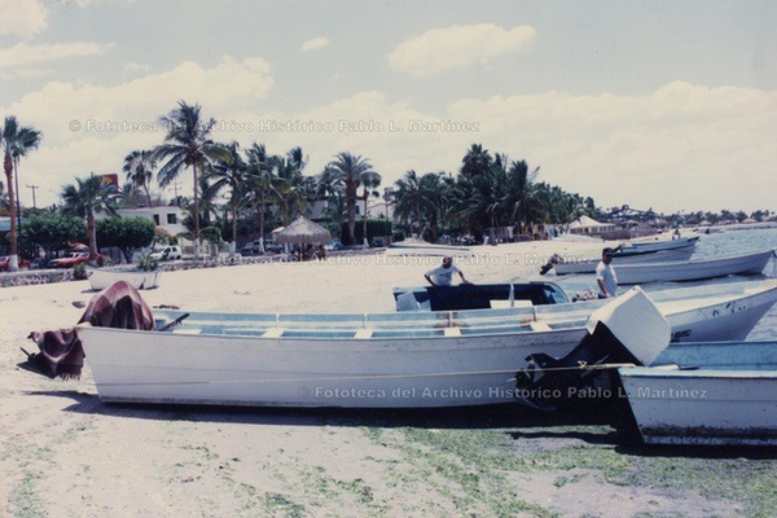 Pescadores y lanchas, en playa del malecón de La Paz.