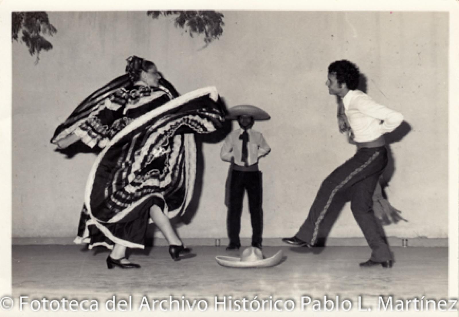 Retrato de grupo que  baila alrededor de sombrero.